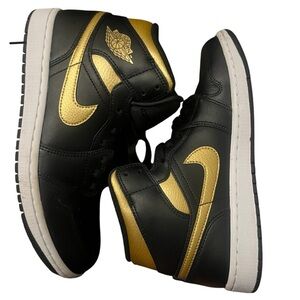 Nike Air Jordan 1 Mid in the black, metallic gold, and white colorway